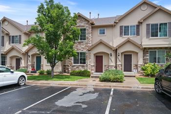 A row of houses with a car parked in front of them.